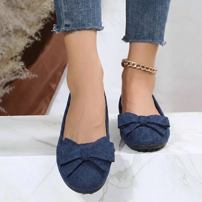 Women's navy bow ballet flats worn from the front