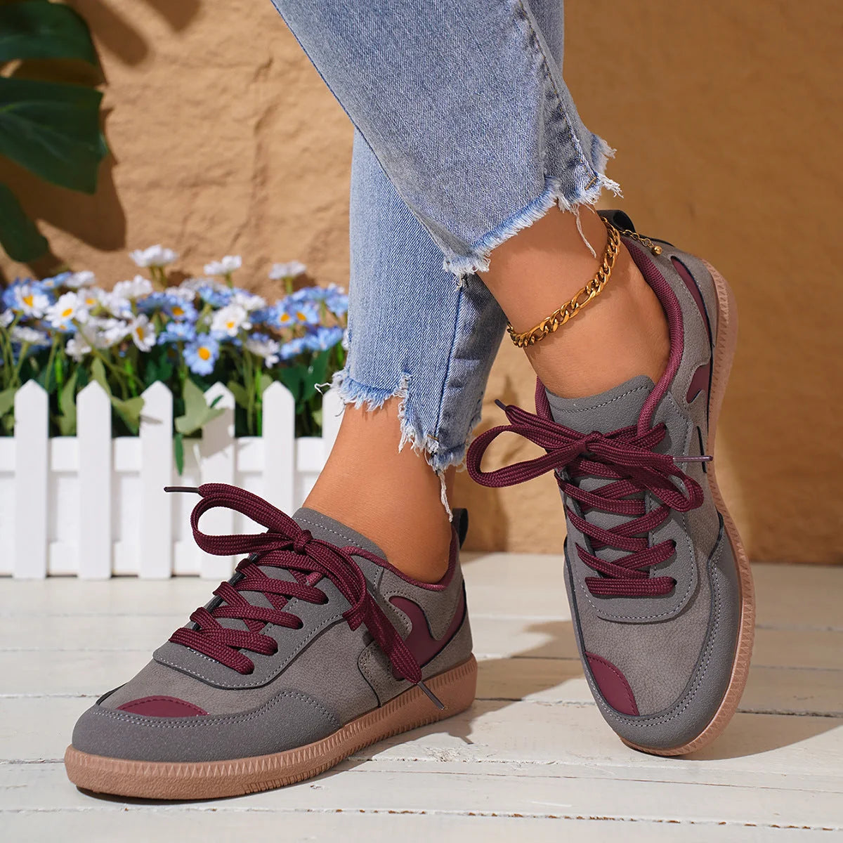 Grey and pink trainers for women, close on-foot view with jeans