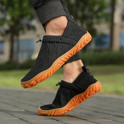 Black barefoot trainers worn outdoors, side view