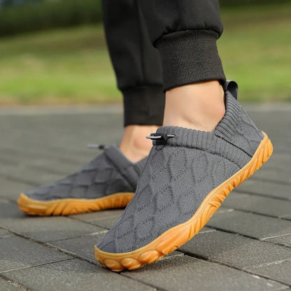 Grey barefoot-style shoes worn outdoors, side view