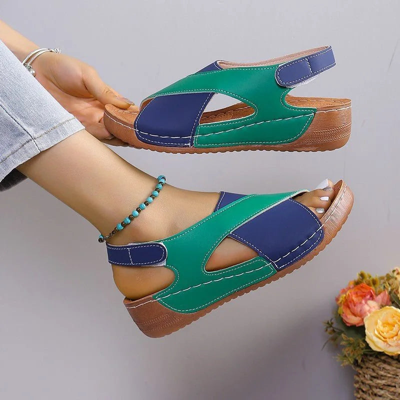 Green and blue criss-cross sandal shown on foot and held from the side