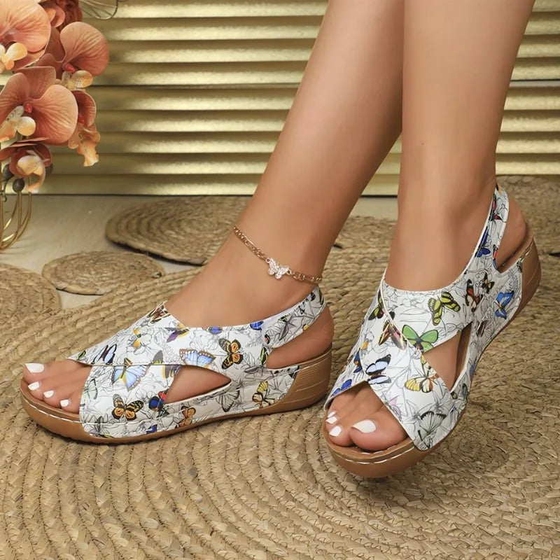 Butterfly pattern walking sandals worn indoors, side view