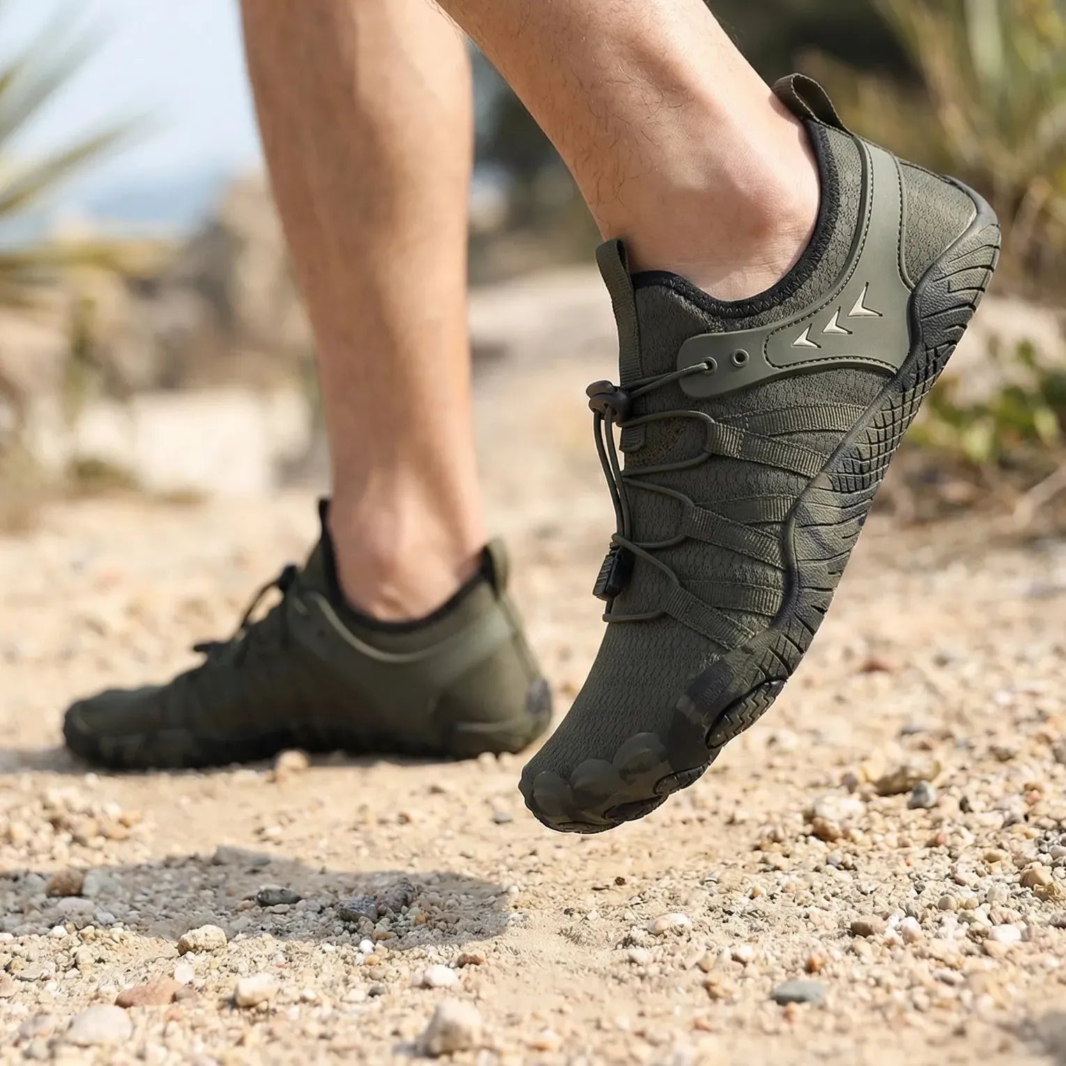 Forest green walking shoes worn on a rocky trail, side view