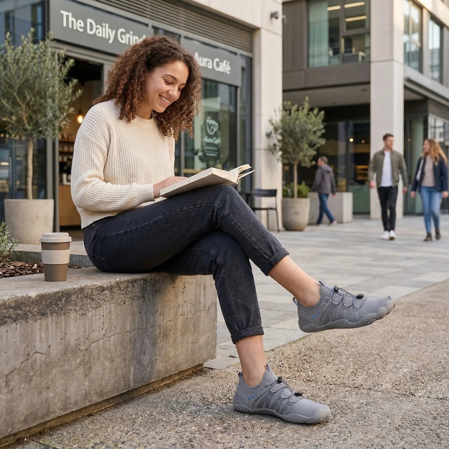 Grey walking shoes worn by a seated woman in a city setting