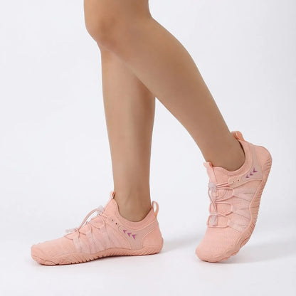 Dusty pink lightweight walking shoes worn in a studio, side view