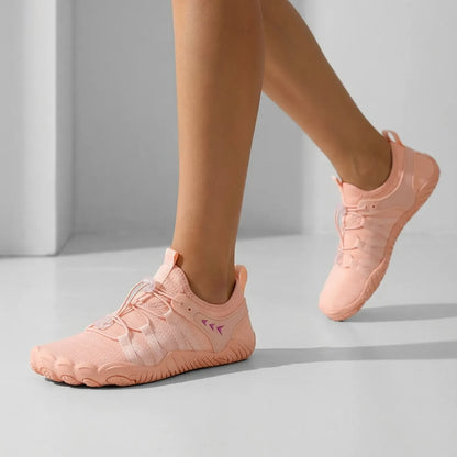 Dusty pink walking shoes worn in a studio, front and side view