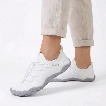 Crisp white walking shoes worn with light trousers, side view