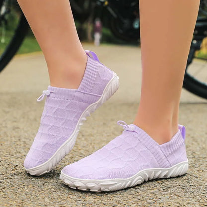 Purple barefoot-style shoes worn outdoors, rear side view