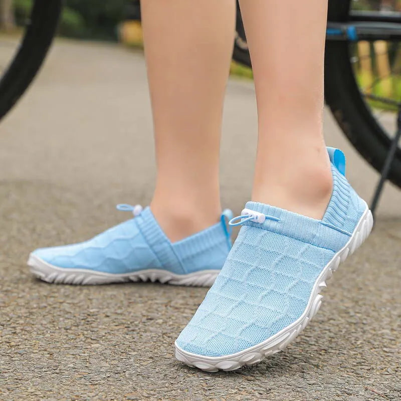 Blue barefoot-style shoes worn outdoors, side view