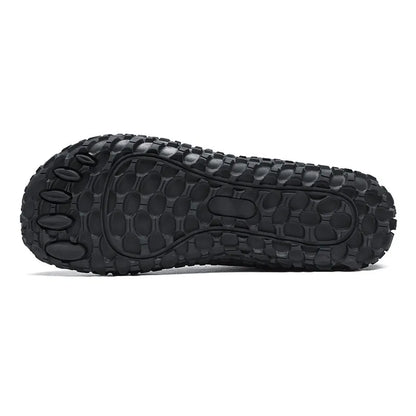 Textured black outsole of a wide toe walking trainer