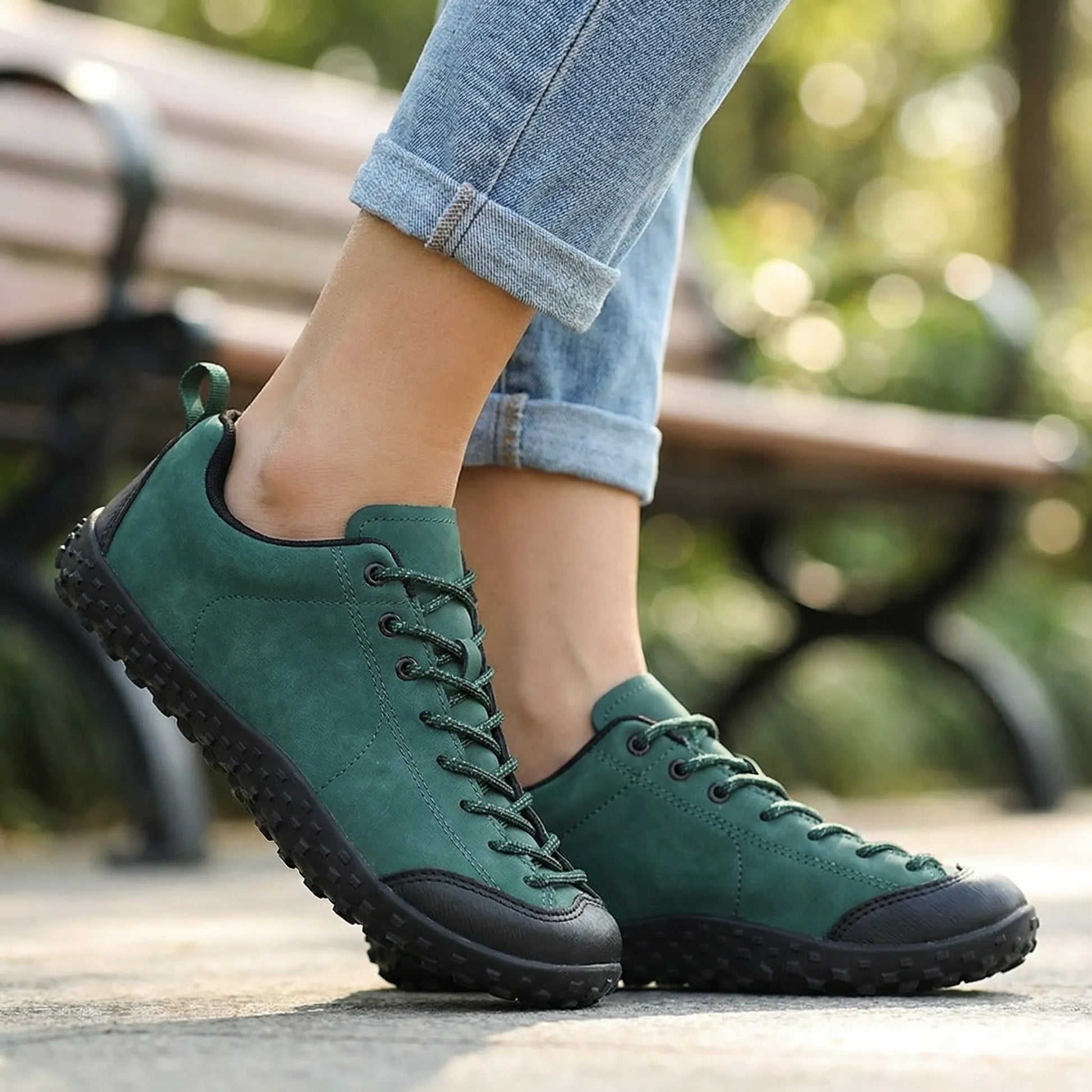 Green wide toe walking trainers worn in side profile outdoors