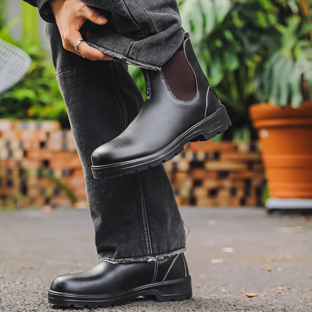 Black Chelsea boots worn outdoors with dark jeans, side view