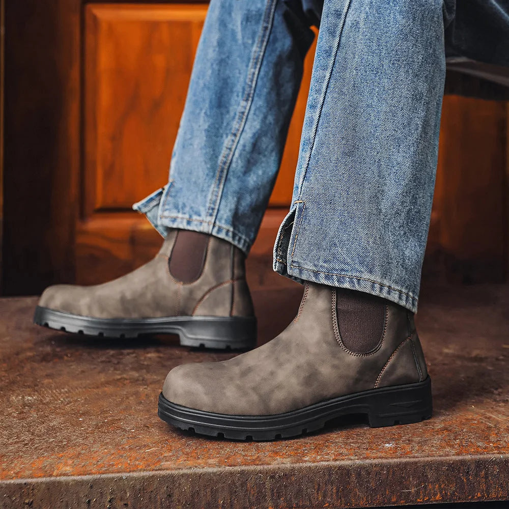 Grey Chelsea boots worn with blue jeans, side view