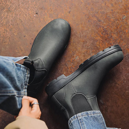 Black Chelsea boots worn while seated, top and side view