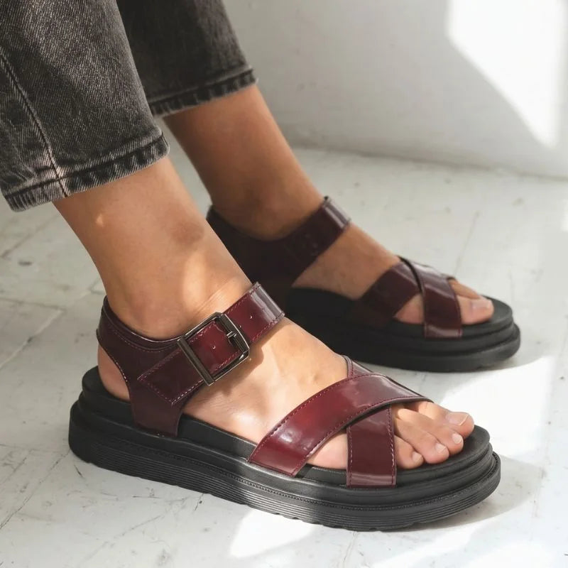Women's brown cross-strap walking sandals worn in side profile