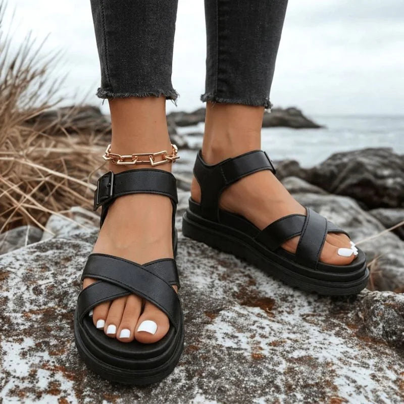 Women's black cross-strap walking sandals worn outdoors from the front