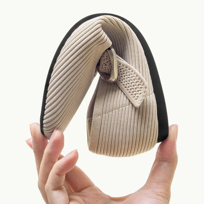Beige square toe Mary Jane flat held folded to show the sole