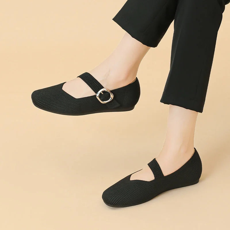 Women's black square toe Mary Jane flats worn in side profile