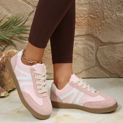 Pink wide fit trainers for women, angled on-foot studio view