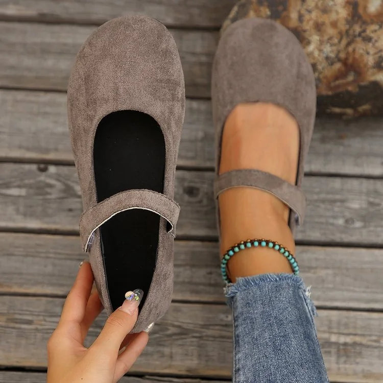 Women's taupe Mary Jane flats viewed from above with one shoe held
