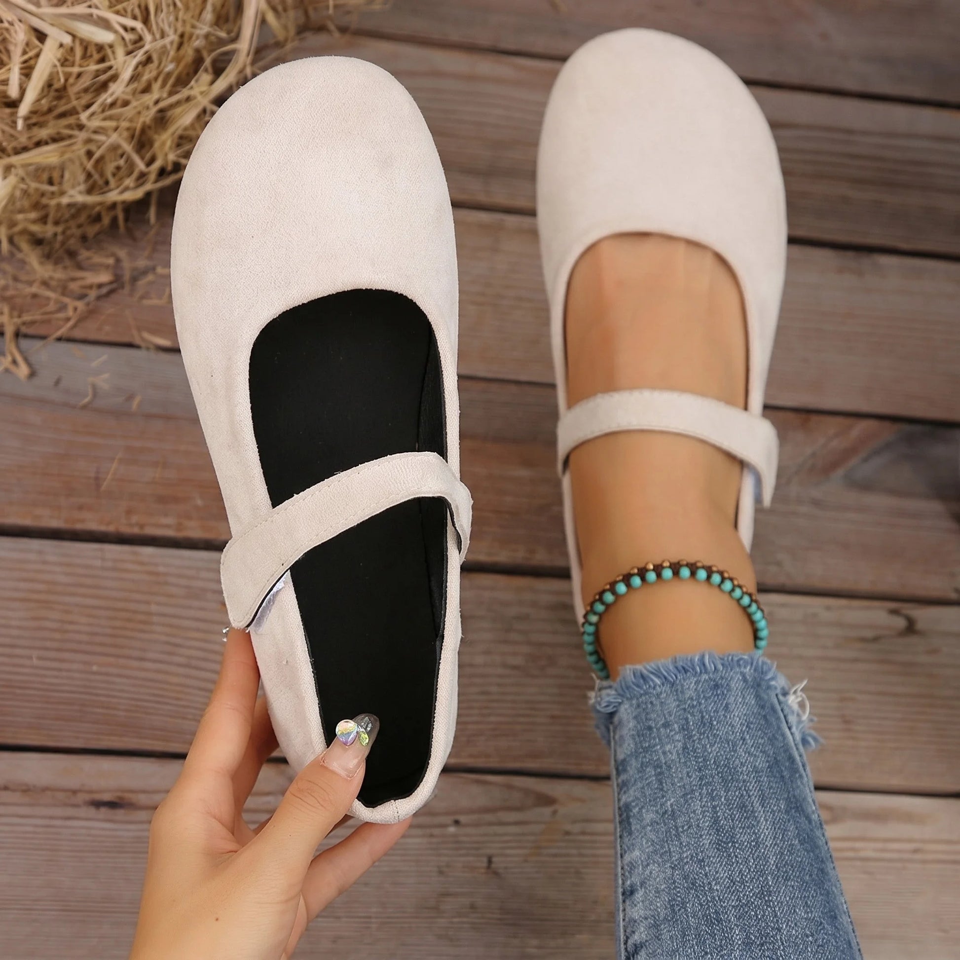 Women's cream Mary Jane flats shown from above with one shoe held