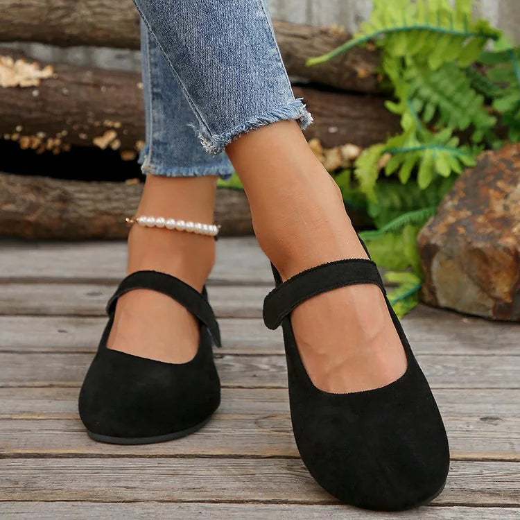 Women's black Mary Jane flats worn outdoors, front view