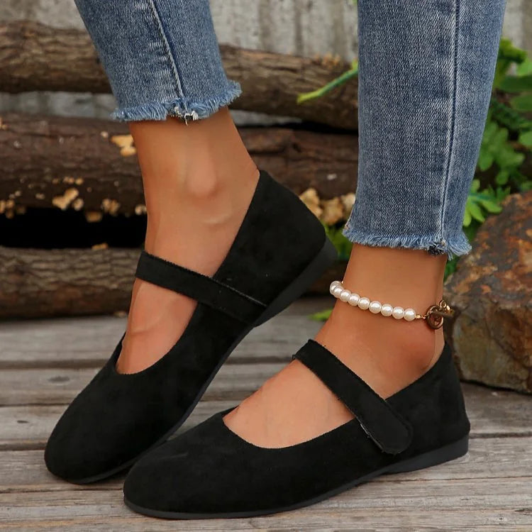 Women's black Mary Jane flats worn in side profile