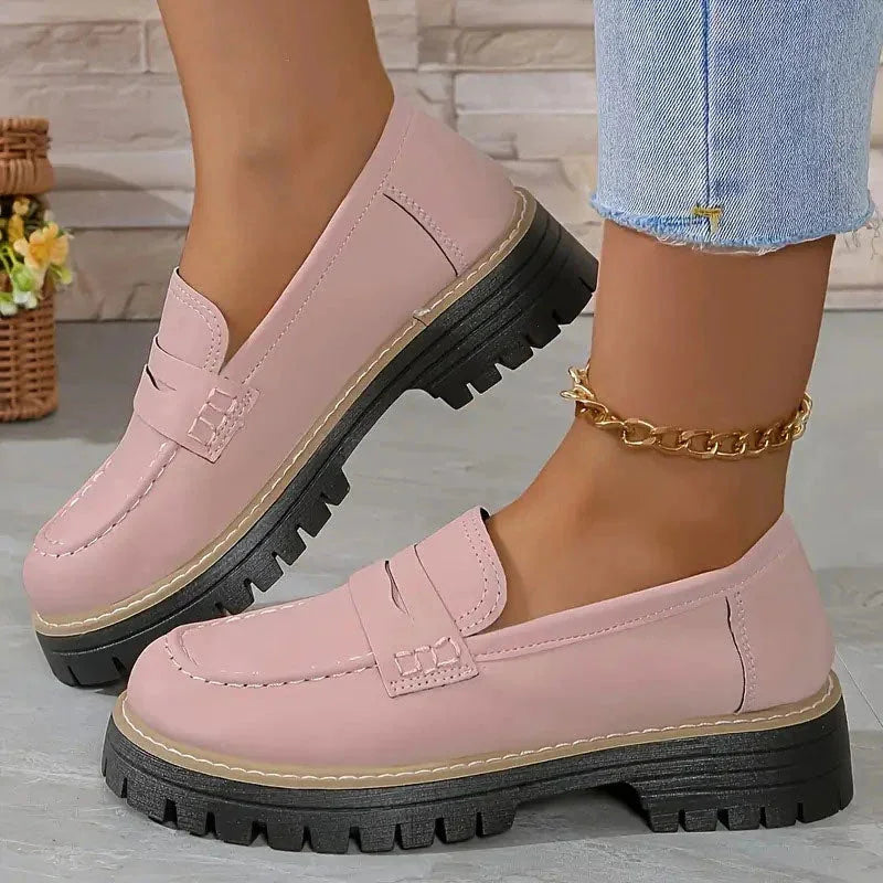 Pink platform loafers worn with jeans, side view