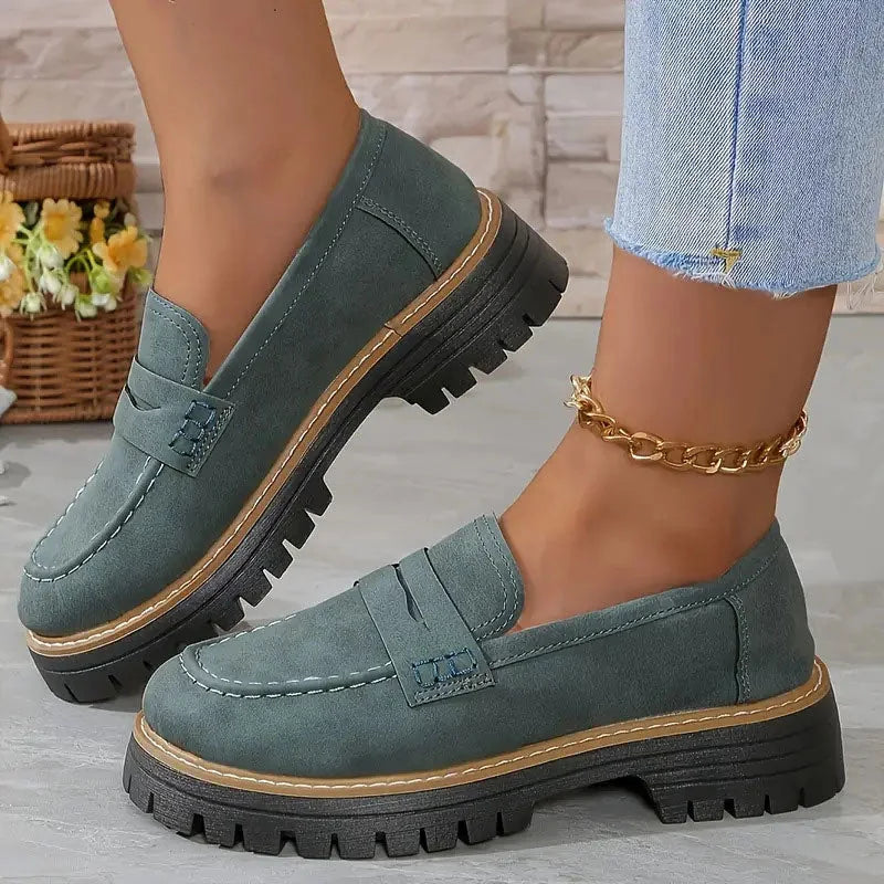 Dark green wide fit loafers worn with jeans, side view
