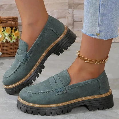 Dark green wide fit loafers worn with jeans, side view
