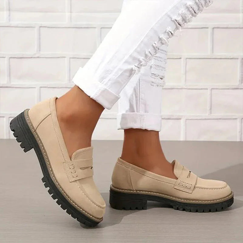 Beige platform loafers worn with white trousers, side view