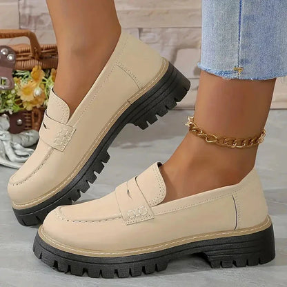 Beige wide fit loafers worn with jeans, close side view