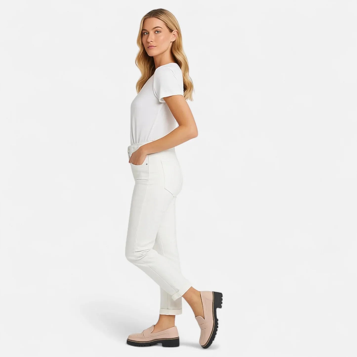 Woman wearing black platform loafers with white trousers, full side view