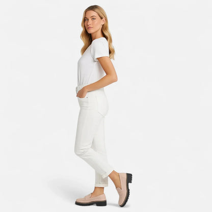 Woman wearing black platform loafers with white trousers, full side view