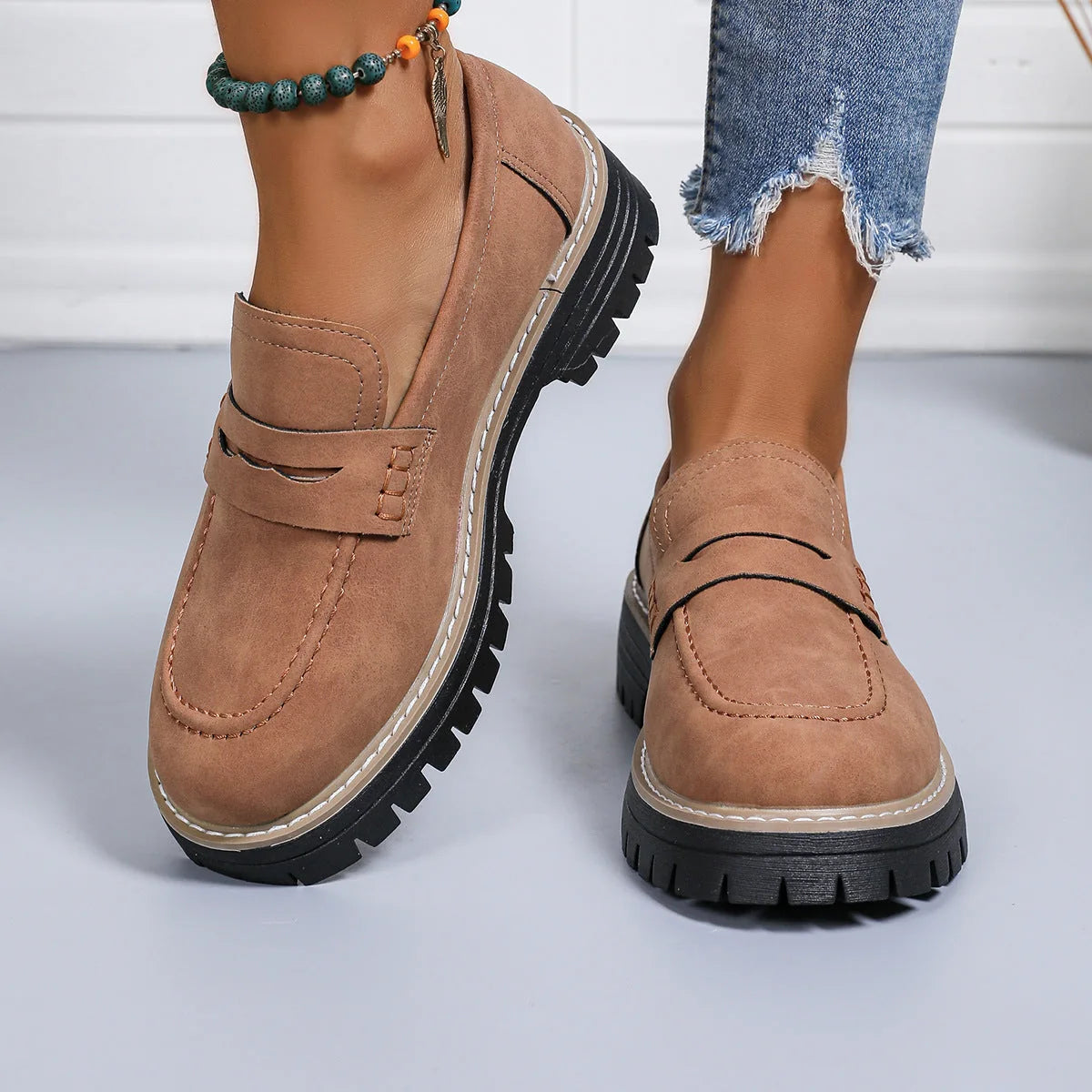 Brown platform loafers worn with jeans, front view