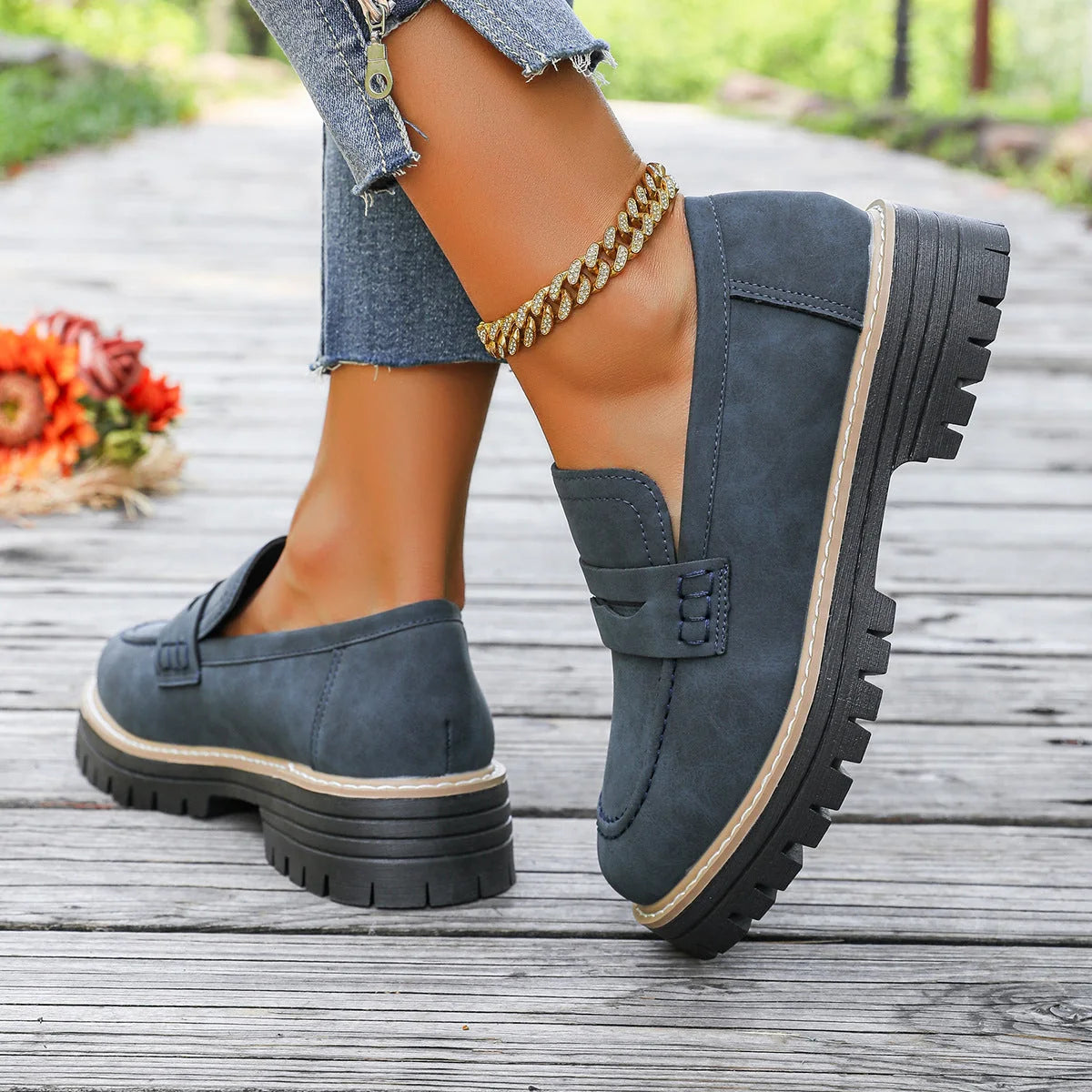 Blue platform loafers worn outdoors, rear side view