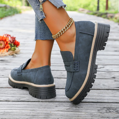 Blue platform loafers worn outdoors, rear side view