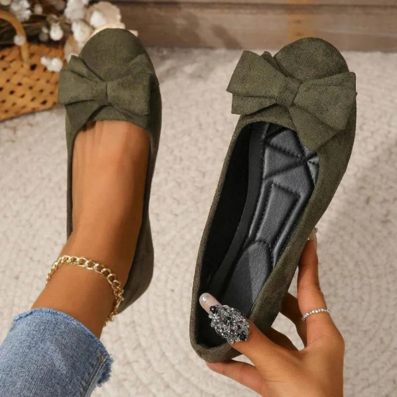 Women's olive bow ballet flats shown on foot with the interior visible