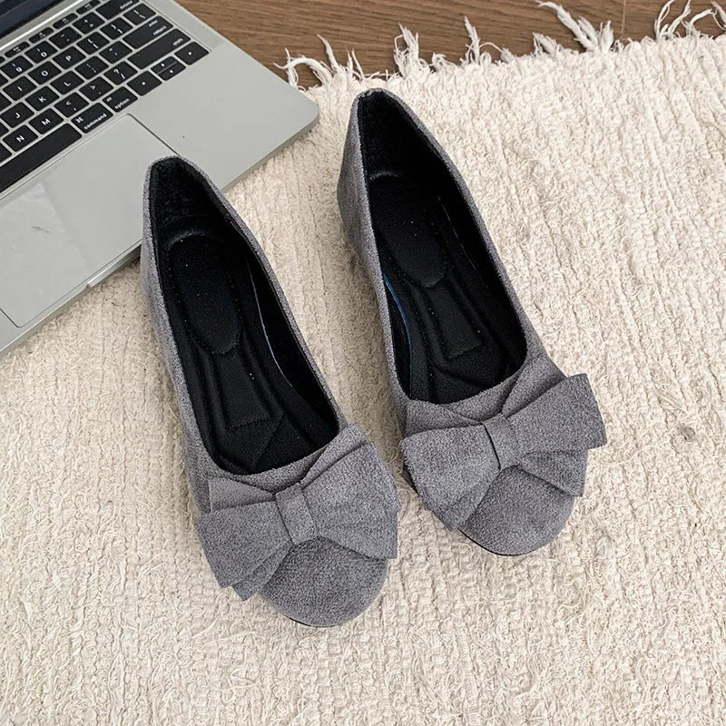 Pair of women's grey bow ballet flats viewed from above
