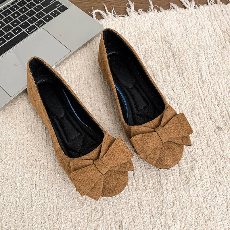 Pair of women's tan bow ballet flats viewed from above