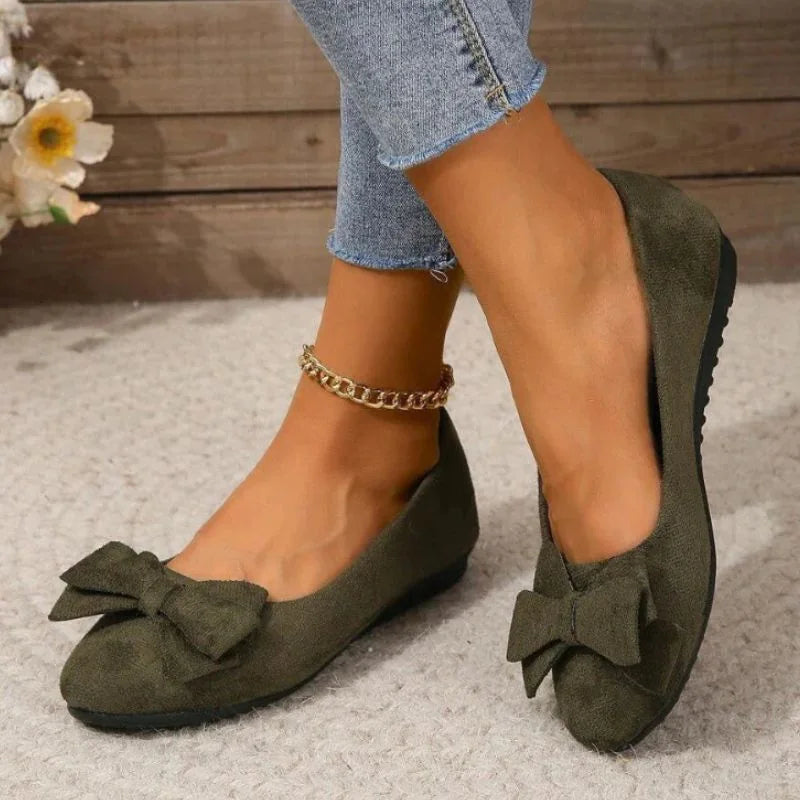 Women's olive bow ballet flats worn in a front three-quarter view