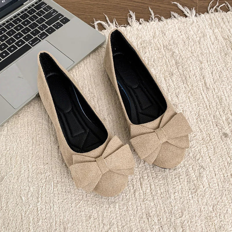 Pair of women's beige bow ballet flats viewed from above