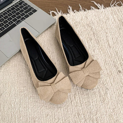 Pair of women's beige bow ballet flats viewed from above