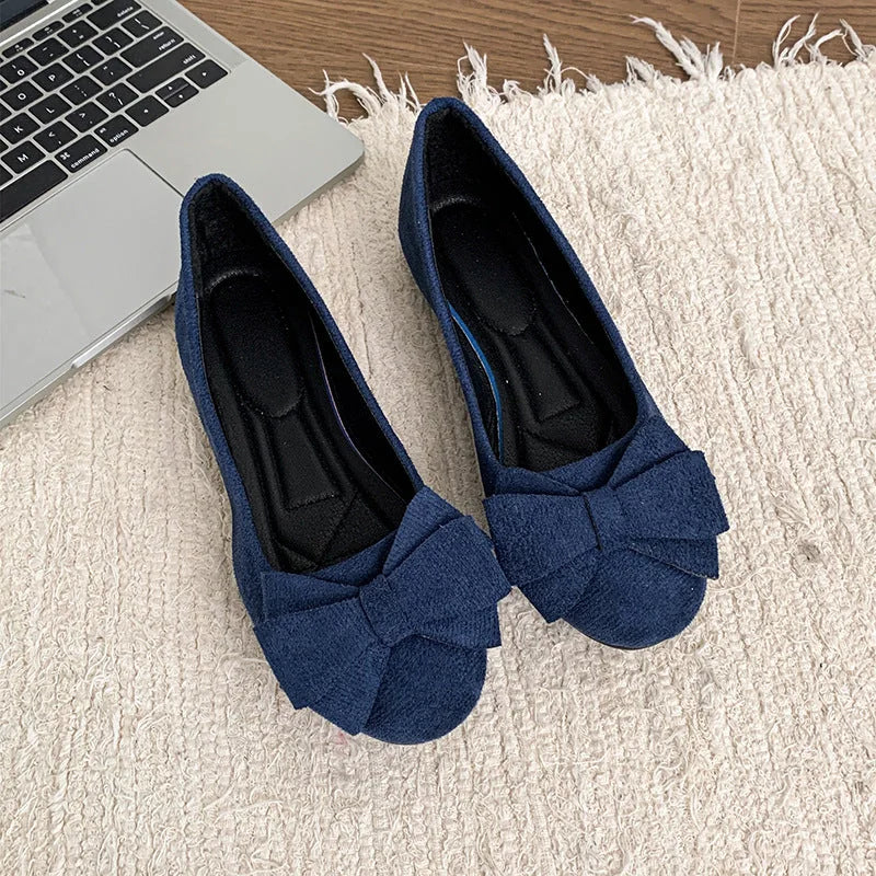 Pair of women's navy bow ballet flats viewed from above