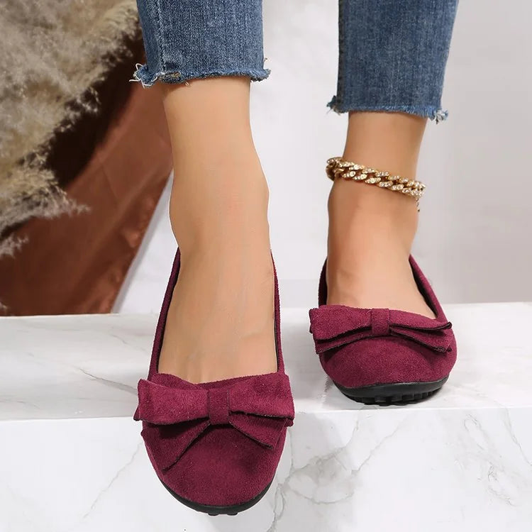 Women's burgundy bow ballet flats worn from the front