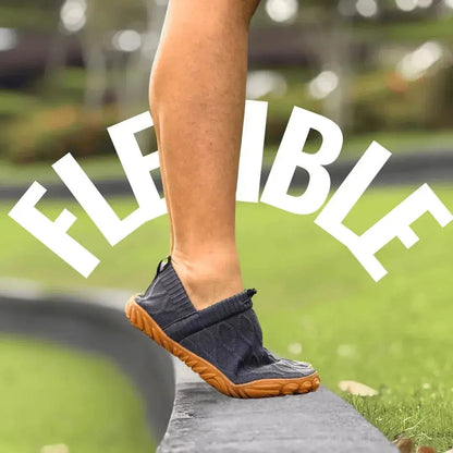Grey flexible barefoot walking shoe bent at the forefoot outdoors