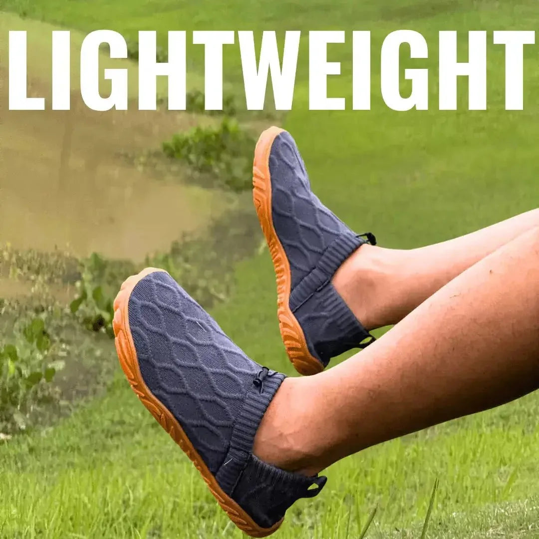 Pair of grey slip-on barefoot walking shoes with orange soles outdoors
