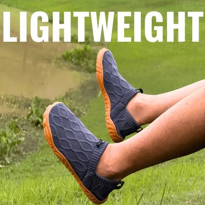 Pair of grey slip-on barefoot walking shoes with orange soles outdoors